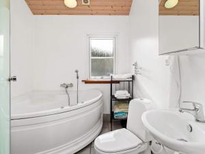 a bathroom with a tub and a toilet and a sink at 8 person holiday home in Hadsund in Hadsund