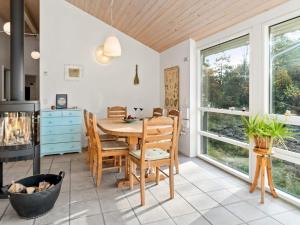 jadalnia ze stołem, krzesłami i oknami w obiekcie 8 person holiday home in Hadsund w mieście Hadsund