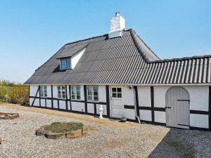 un edificio blanco y negro con techo en 4 person holiday home in Tranek r, en Tranekær