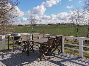 una mesa y sillas en una terraza con vistas a un campo en 5 person holiday home in Vordingborg, en Vordingborg