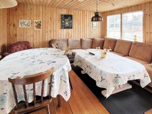 a living room with two tables and a couch at Holiday home Allingåbro XXIII in Allingåbro