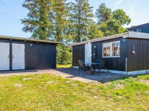 a backyard with a table and chairs and a shed at Holiday home Allingåbro XXIII in Allingåbro