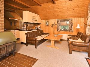a living room with leather furniture and a kitchen at 6 person holiday home in N rre Nebel in Nørre Nebel