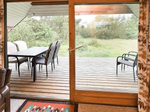 a wooden deck with a table and chairs on it at 6 person holiday home in N rre Nebel in Nørre Nebel