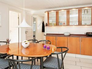 a kitchen and dining room with a wooden table and chairs at 8 person holiday home in Glesborg in Glesborg