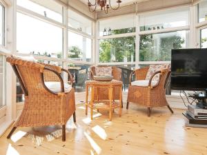 a living room with wicker chairs and a tv at 8 person holiday home in Glesborg in Glesborg