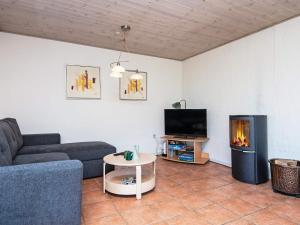 ein Wohnzimmer mit einem Sofa und einem Kamin in der Unterkunft 4 person holiday home in B rkop in Børkop