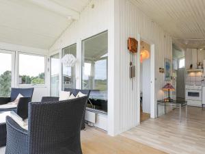 a living room with chairs and a table and windows at 5 person holiday home in Vejers Strand in Vejers Strand