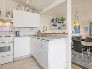 una cucina con elettrodomestici bianchi e una sala da pranzo di 5 person holiday home in Vejers Strand a Vejers Strand