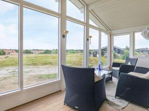 una veranda schermata con finestre che si affacciano su un campo di 5 person holiday home in Vejers Strand a Vejers Strand