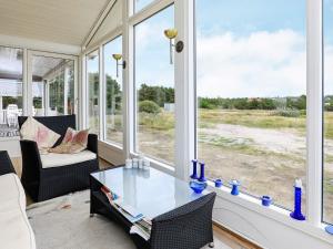 バイアス・スタンにある5 person holiday home in Vejers Strandのガラスのテーブルと椅子が備わるポーチ