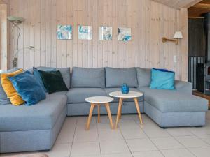 Knebelにある7 person holiday home in Knebelのリビングルーム(青いソファ、テーブル付)