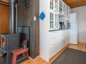a kitchen with a stove and white cabinets at 7 person holiday home in Knebel in Knebel