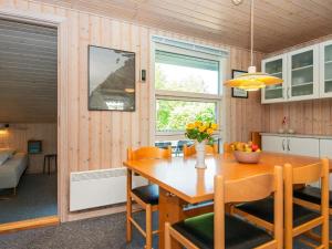 Tarmにある6 person holiday home in Tarmのキッチン、ダイニングルーム(木製のテーブルと椅子付)