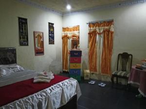 ein Schlafzimmer mit einem Bett, einem Tisch und einem Stuhl in der Unterkunft Pondok Wisata Likupang in Palaes