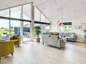 a living room with couches and chairs and windows at Luxury Retreat for 18 - By Traum Ferienwohnungen in Spottrup