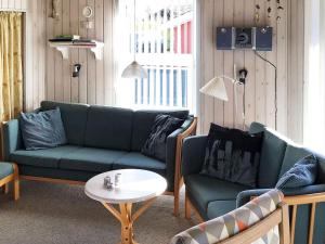 a living room with two couches and a table at 4 person holiday home in Hemmet in Hemmet
