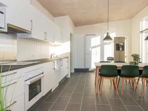 eine Küche mit einem Tisch und grünen Stühlen in der Unterkunft 6 person holiday home in Ringk bing in Ringkøbing
