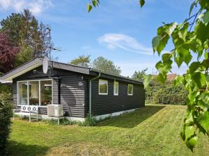 une petite maison noire avec une cour dans l'établissement 6 person holiday home in Allinge, à Allinge
