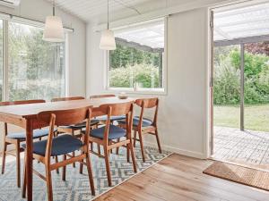 una sala da pranzo con tavolo e sedie in legno di 6 person holiday home in Allinge ad Allinge