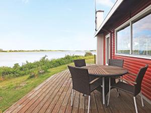 una mesa y sillas en una terraza con vistas al agua en 4 person holiday home in Martofte, en Martofte