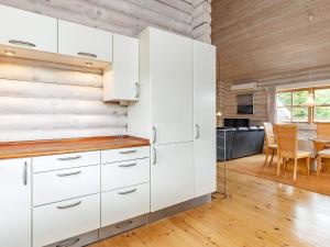 a kitchen with white cabinets and a dining room at 8 person holiday home in Fr rup in Tårup