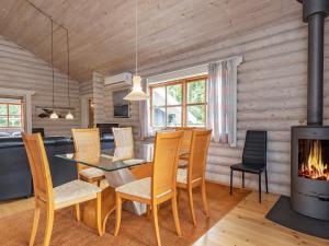 a dining room with a table and chairs and a fireplace at 8 person holiday home in Fr rup in Tårup