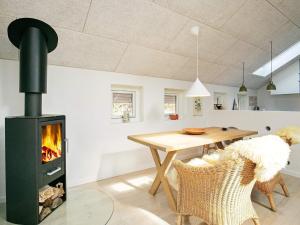 a kitchen and dining room with a wood stove in a room at Holiday home Læsø VII in Læsø