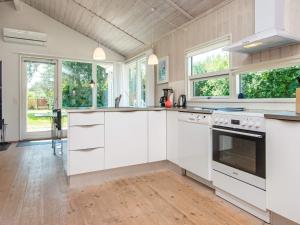 a kitchen with white cabinets and windows at 8 person holiday home in Ebeltoft in Ebeltoft