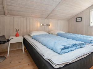 a large bed with blue sheets in a room at 8 person holiday home in Ebeltoft in Ebeltoft