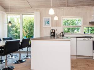 uma cozinha com um balcão com cadeiras e uma mesa em 8 person holiday home in Ebeltoft em Ebeltoft