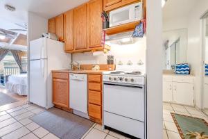 una cocina con electrodomésticos blancos y armarios de madera en Kihei Bay Surf 236 en Kihei
