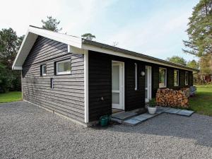 una casita blanca y negra con porche en 6 person holiday home in Gr sted, en Græsted