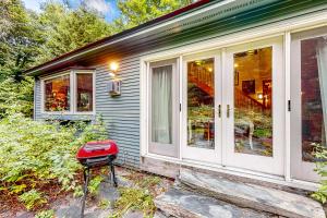 un tabouret rouge assis à l'extérieur d'une maison dans l'établissement Azure Abode, à Warren