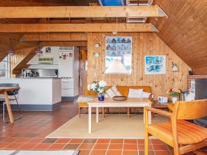 a living room with a table and a kitchen at 6 person holiday home in Ringk bing in Ringkøbing