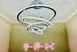 a chandelier hanging from a ceiling with a neon sign at Heartbeat Of ATL- Gated Community, Pool, Gym, and much more! in Atlanta