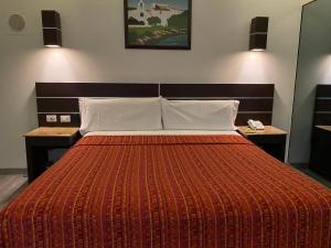 a bedroom with a large bed with a orange blanket at HOTEL MIRAMAR in Mexico City