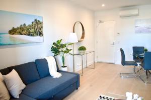 a living room with a blue couch and a table at VUEonKW in Adelaide