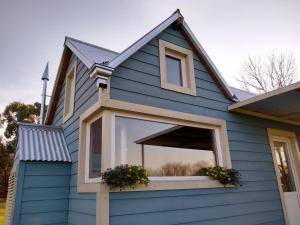 a blue house with a window with flowers on it at Tiny House, La Candelaria in Luján
