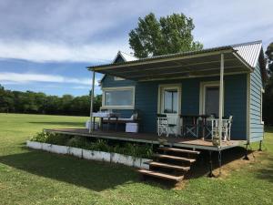 a green tiny house with a porch and a deck at Tiny House, La Candelaria in Luján