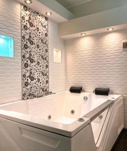 uma banheira branca numa casa de banho com uma parede em preto e branco em Santa Lucía Suite Hotel em Chachapoyas