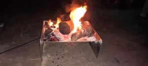 un grill avec un feu dans le sol dans l'établissement Childers Nature Camp, à Childers