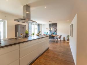 a kitchen with white cabinets and a dining room at Studio 7 in Niedernsill
