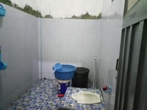 a small bathroom with a blue bucket on the floor at Pondok Wisata Likupang in Palaes