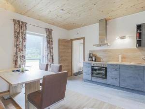 een keuken met een houten tafel en een eetkamer bij Tobias Top 2 in Bramberg am Wildkogel