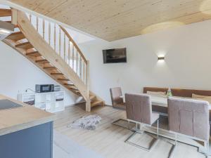 een woonkamer met een tafel en stoelen en een trap bij Tobias Top 2 in Bramberg am Wildkogel