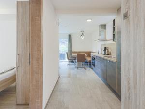 a kitchen with wooden cabinets and a dining room at Celine Top 3 in Bramberg am Wildkogel