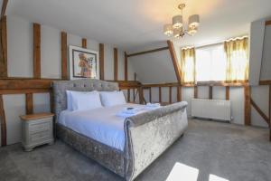 a bedroom with a bed and a couch in it at Moat Barn in Debach
