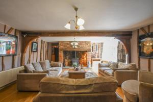 uma sala de estar com sofás e uma lareira em Moat Barn em Debach