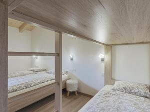 two bunk beds in a room with wooden ceilings at Michaela in Bramberg am Wildkogel
